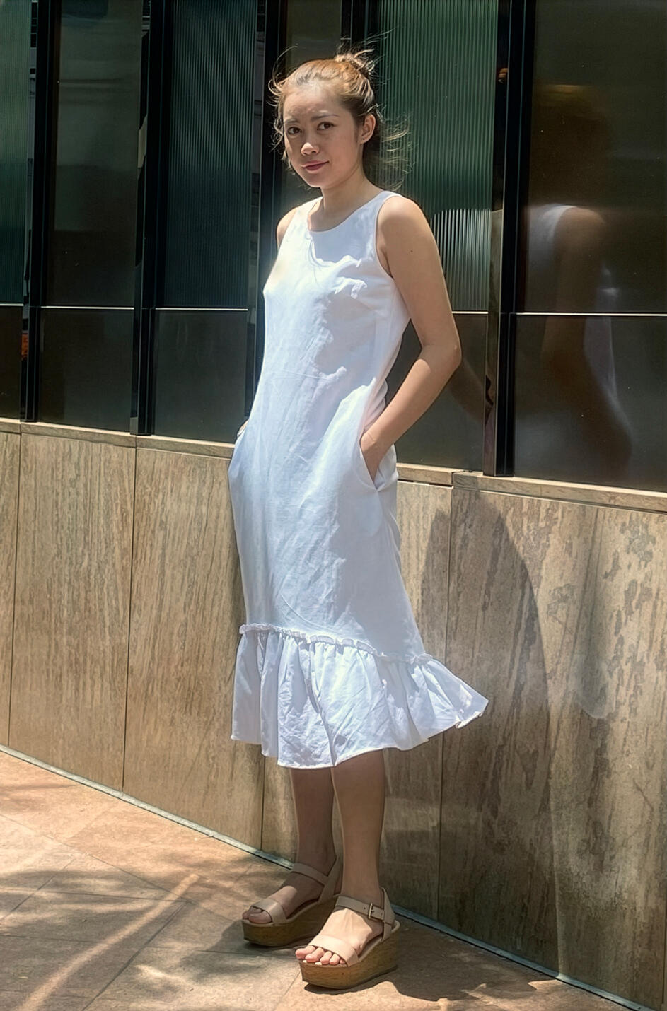 Woman wearing a custom white dress designed and tailored by Vy in New York City